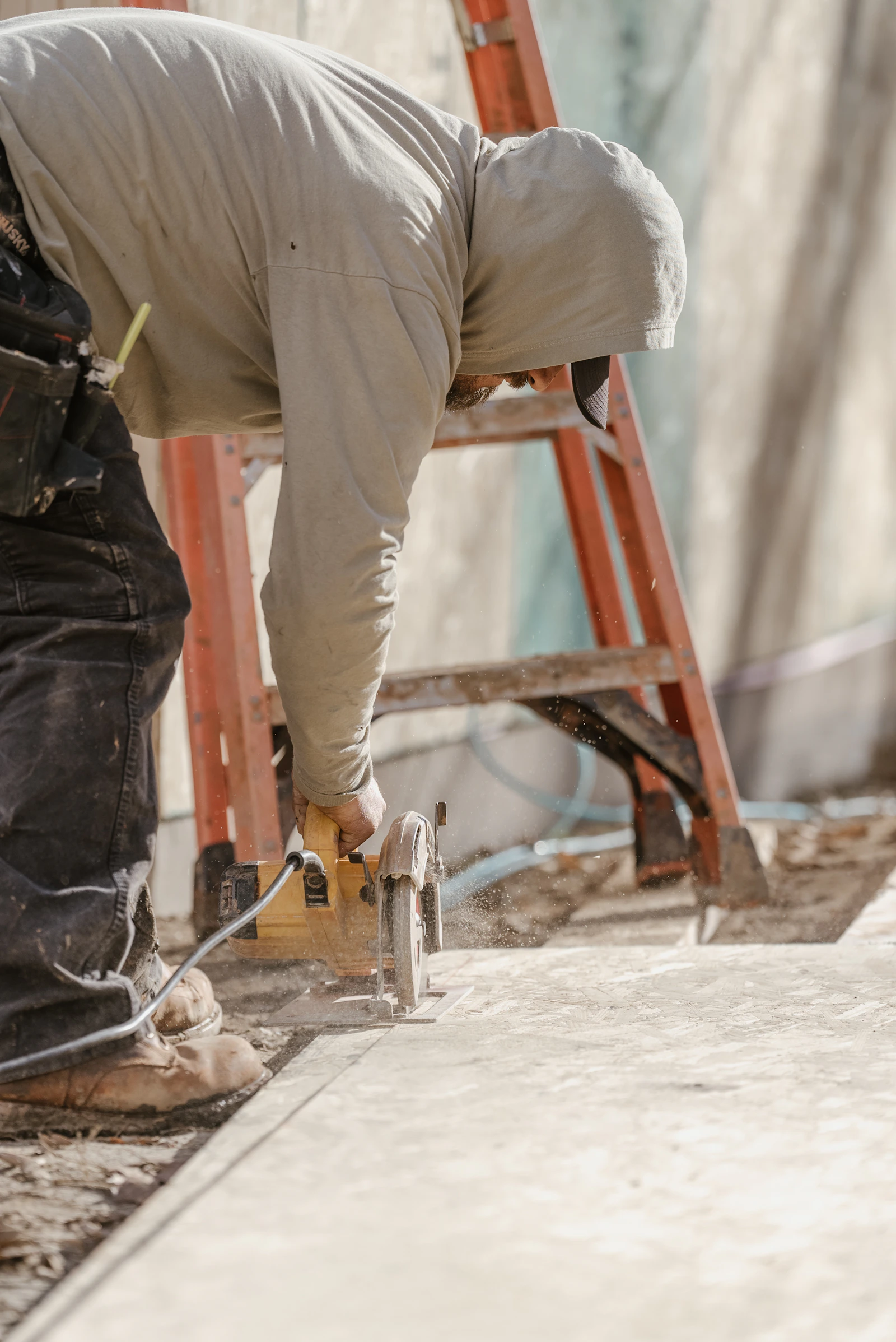 A carpenter carefully cutting timber on a residential construction site